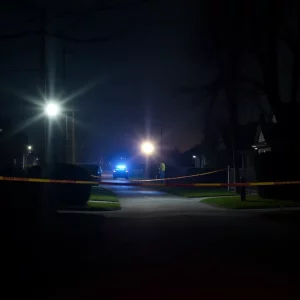 Police lights illuminating a Roxbury neighborhood at night