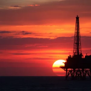 An oil rig at sunset symbolizing OPEC+ oil production.
